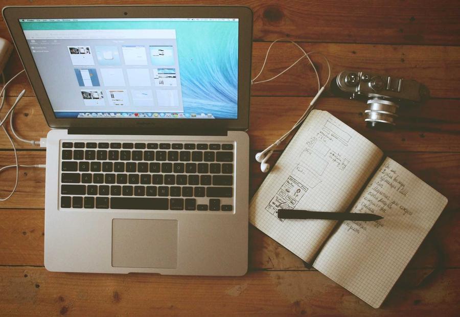 Laptop beside hand-drawn website wireframes for Atlas Finance